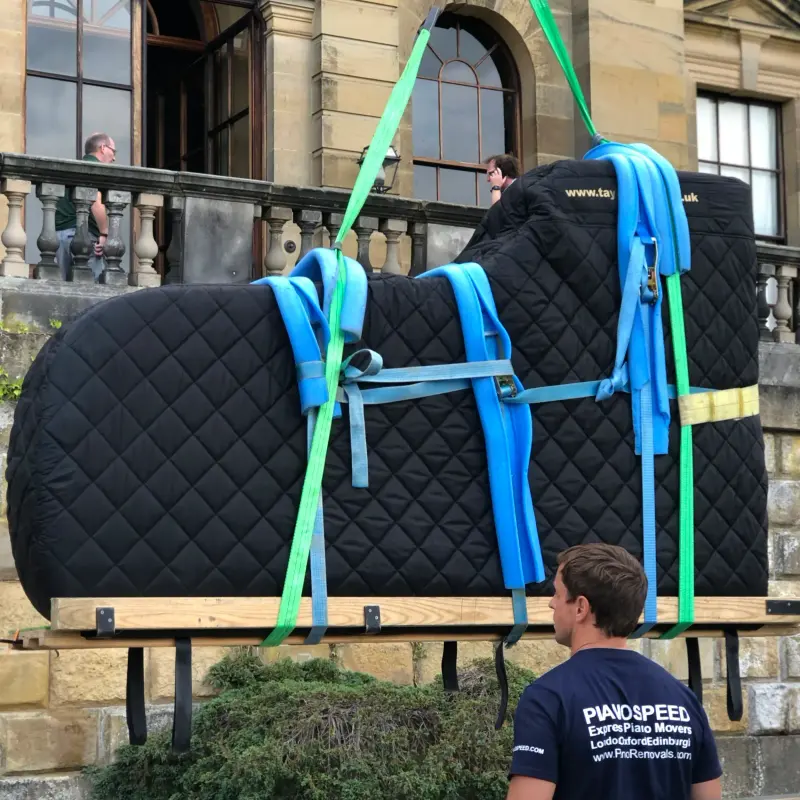 Concert grand piano lifted on straps