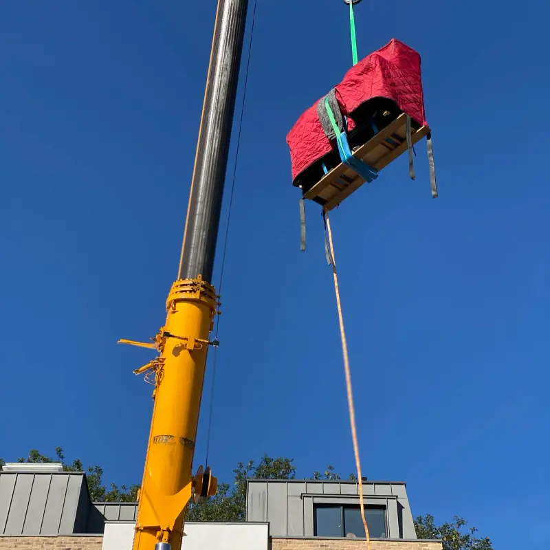 Piano in a quilted transit cover lifted by crane